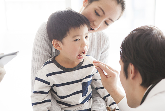 のどの奥を診察される子供